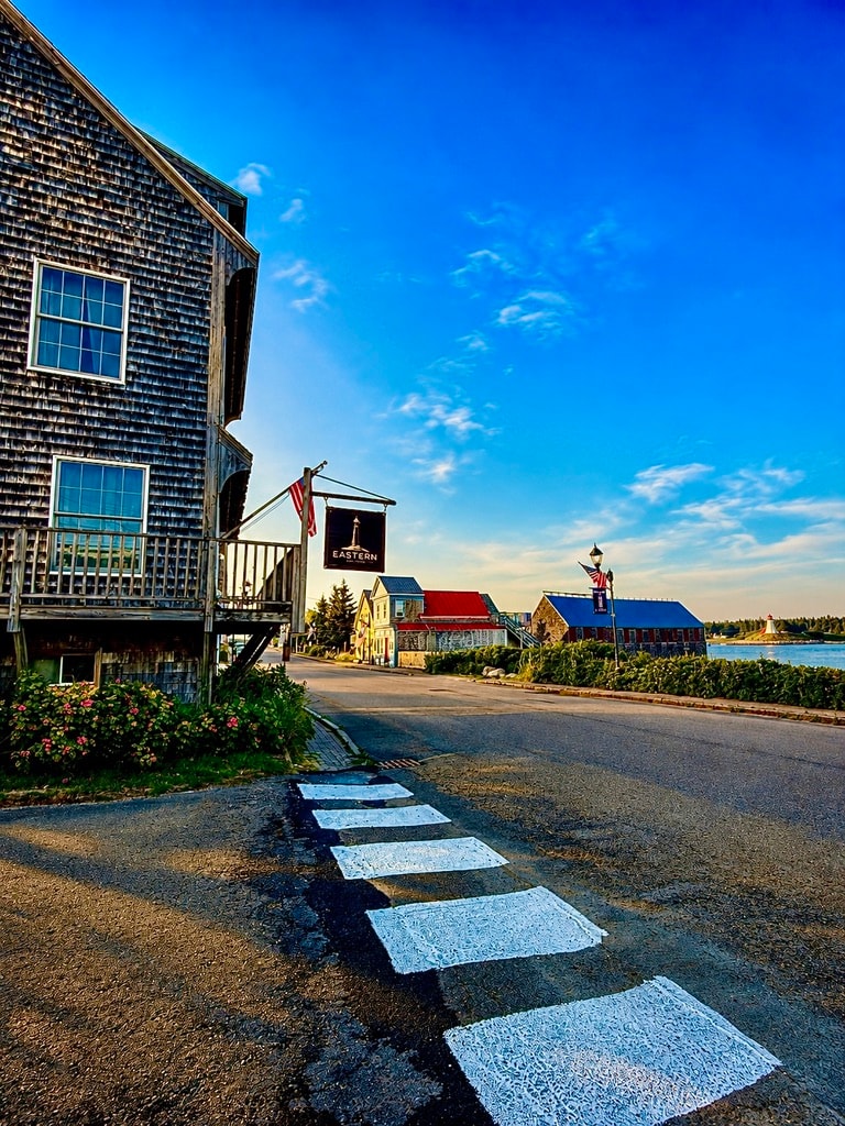 Waterfront building and distant lighthouse along the Maine coast