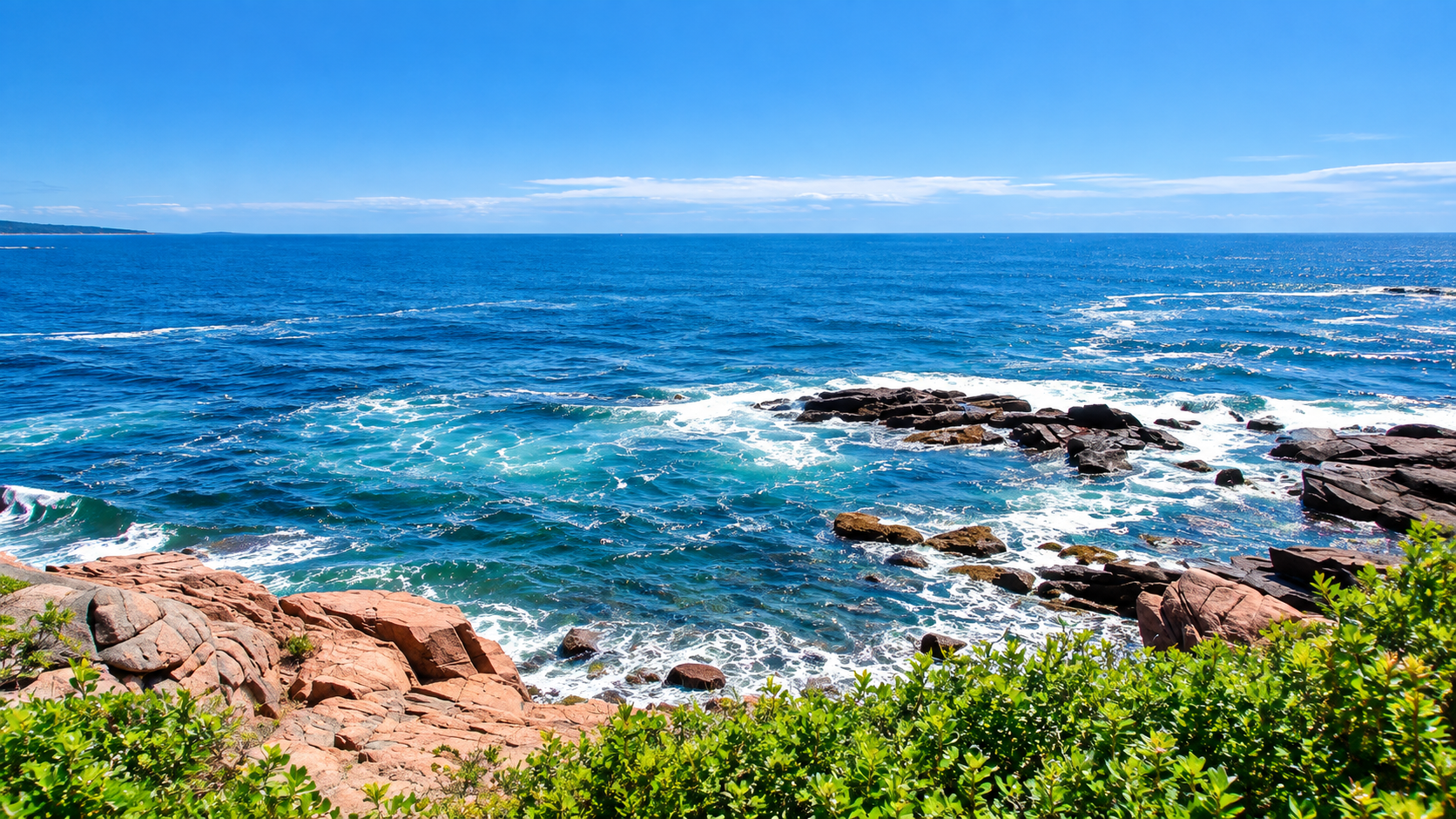 Rocky granite shoreline with crashing Atlantic waves and vivid blue sky at Schoodic Point, Acadia
