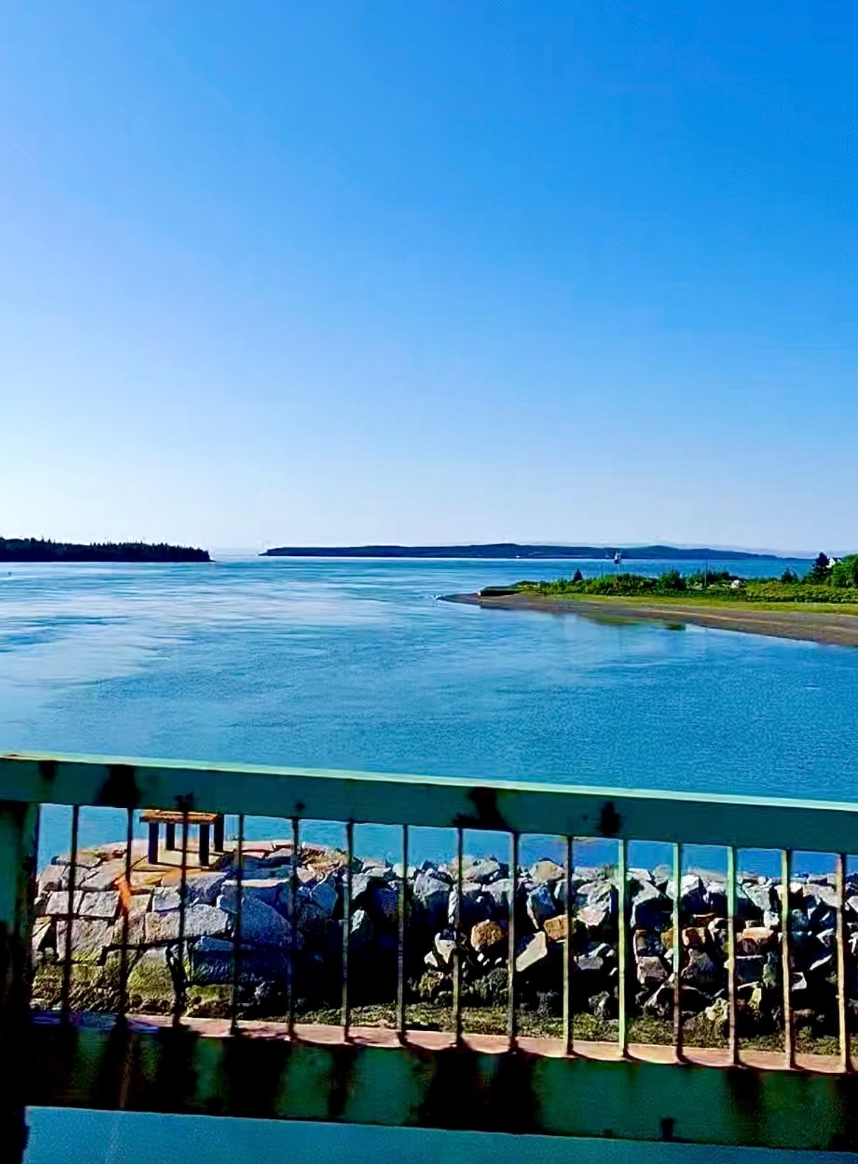 Blue water and distant shoreline viewed from the bridge crossing the narrows