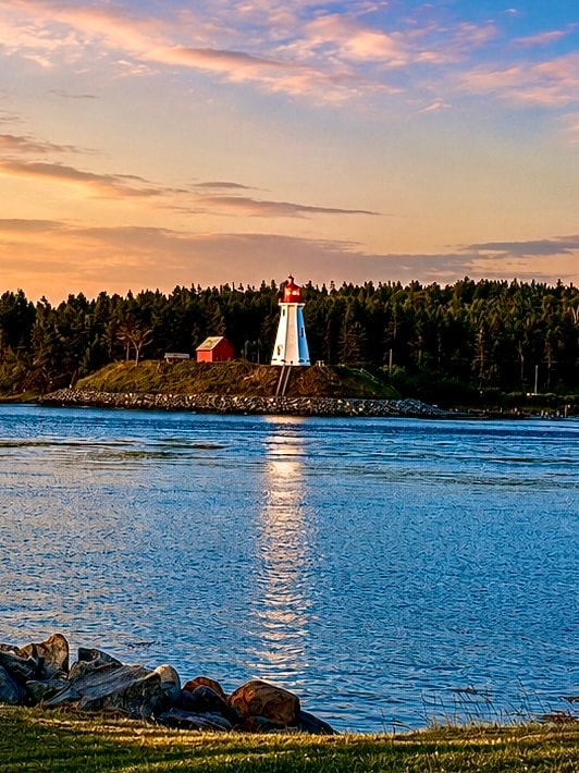 Mulholland Point Lighthouse reflected in calm water at sunset