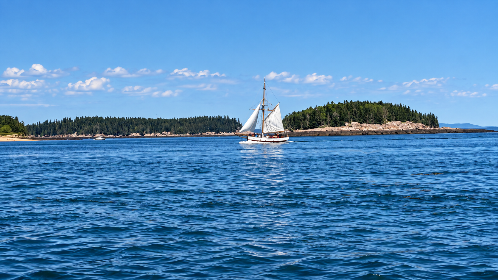 Sailboat on Maine coastal waters with forested islands
