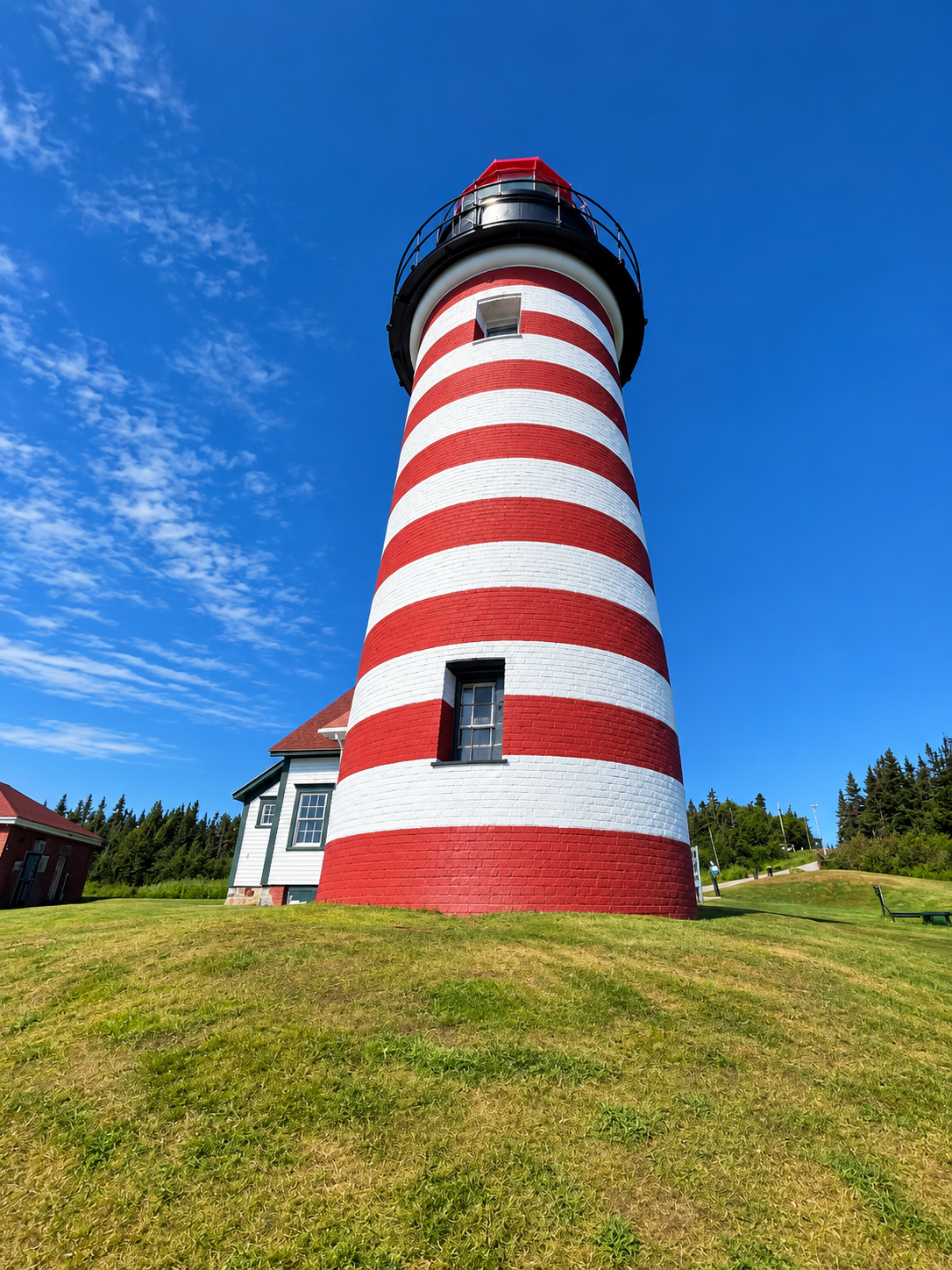 Close-up of West Quoddy Head Lighthouse against a bright blue sky